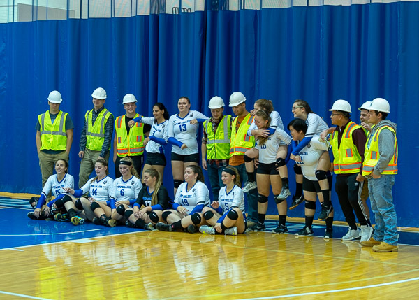 First-year construction management students from assistant professor Wayne R. Sheppard's Construction and Program Orientation class join members of the women's volleyball team at Saturday's game. The students are encouraged to attend various campus activities, but there is a catch: They have to wear their personal protective equipment, which includes hard hat and safety vest, to the events!