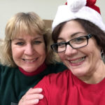 DePasqua (in Santa hat) and Karen P. Fessler, the college's director of procurement services, aid the food bank's holiday distribution.