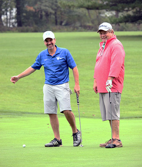 Alumnus Bryan Waltz (left), manager of telecommunications and networking, and Marc E. Bridgens, associate professor of HVAC technology, fill their scorecard with smiles.