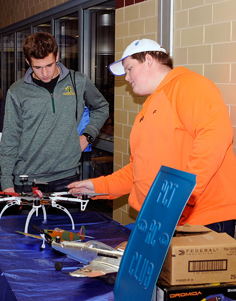 At a gadget-laden table touting the college's Remote Control Club, a guest talks with Ryan S. McCrickerd, an aviation maintenance technology major from Bethlehem. 