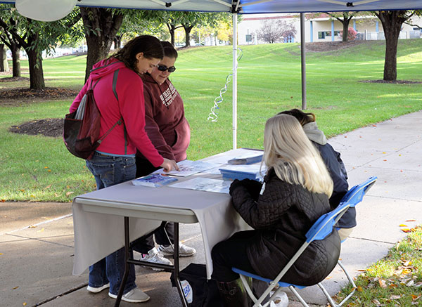 Visitors stop for directions at a convenient information tent staffed by LaDonna J. Caldwell (foreground), director of compensation and benefits, and Student Ambassador Elizabeth J. Wellar.