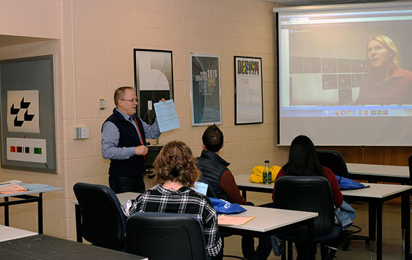 Amid walls displaying student work and a video featuring 2007 alumnus Nicholas D. Biddle, visitors hear from Brian A. Flynn, assistant professor of graphic design, and other art faculty.
