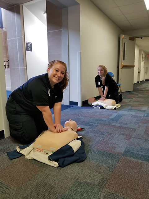 Aided by the persistent beat of their musical playlist, emergency medical services students Courtney L. Breon (foreground), of Jersey Shore, and Kayla M. Vincent taught more than a dozen people to do hands-only CPR.