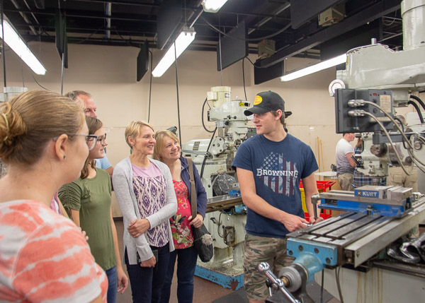 In the Machining Technologies Center, Isaac E. Shaw, a machine tool technology student from Millerstown, explains some of the equipment to his family, including his parents, grandmothers and sisters.