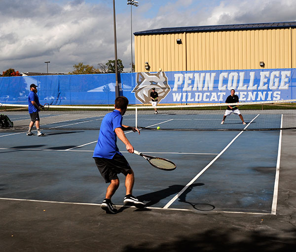 A Wildcat banner attests to this doubles team's home-court advantage ...