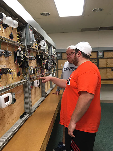 Michael T. Weber, whose parents (Tom  and Mary Anne) traveled from Millersville, shows Dad his heating, ventilation and air conditioning technology lab.