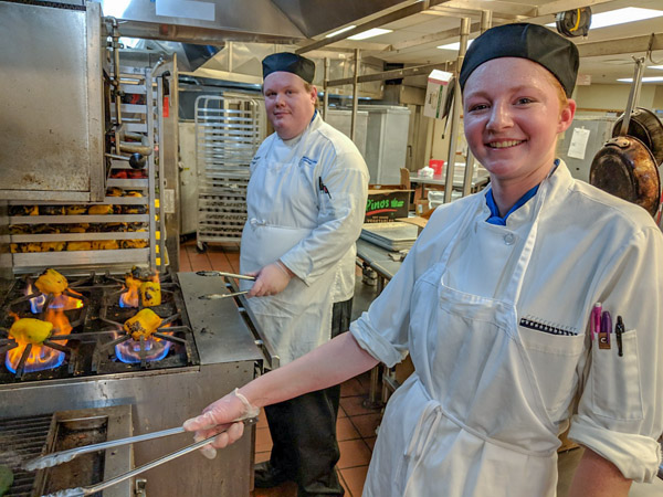Culinary arts and systems student Timmons, of Greencastle, and baking and pastry arts student Amanda M. Brandt, of Etters, roast peppers in a Churchill Downs kitchen.