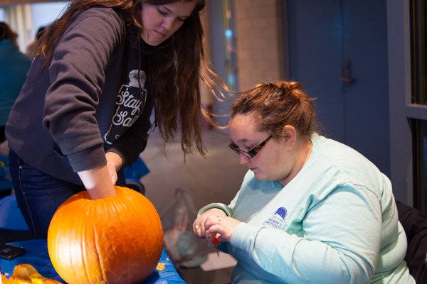 Collaborating on their pumpkin project (the gooey part included) are 2018 human services alumna Keri D. Fargus (left) and Bernice C. Weaver, of Newville, majoring in residential construction technology and management: building construction technology concentration.