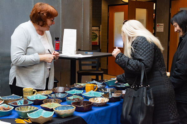 Dining Services manager Vicki K. Killian helps a patron faced with an unenviable challenge: Which bowl to choose?