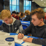 Students from Berwick Area School District hash out their target audience and sales territory. They are pitching a business that manufacturers an add-on component for hybrid vehicles.