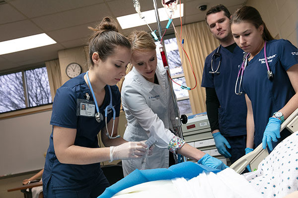Pennsylvania College of Technology’s Tushanna M. Habalar, instructor of nursing, guides student Lindsay C. Dunkelberger (left), of Centre Hall, in placing an IV in SimMan, a wirelessly controlled patient simulator.