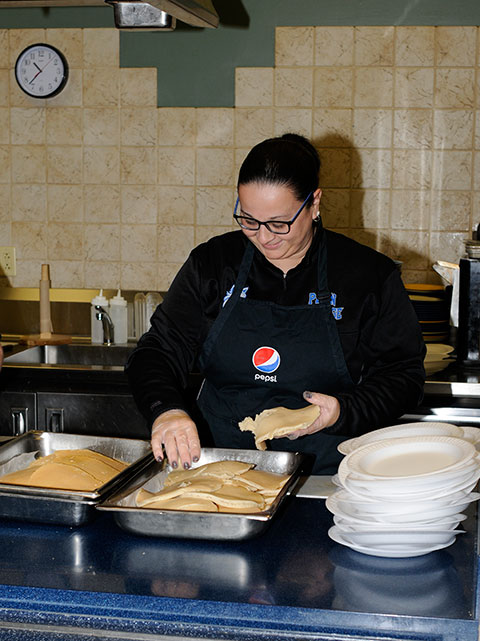 Softball coach Jackie Klahold keeps up with the demand for pancakes: 205 students served in the first 15 minutes alone.