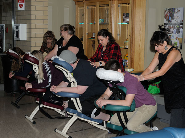A group of licensed massage therapists helps to unknot test-tightened muscles outside the dining unit.