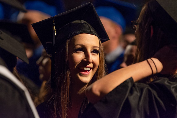 As faculty march to the stage, anticipation and fulfillment blend on a student's radiant face. 