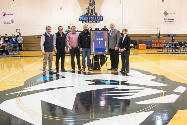 ... and joins in the formal photo opportunity at center court. From left are Brandon Hugo, Business Development Center manager for the dealerships; Andrew Becker, sales manager at Alexander Kia; Joel Breneman, Alexander's chief information officer; Aubrey Alexander, the company’s property manager; Vandevere; and Loni N. Kline, vice president for institutional advancement at Penn College.