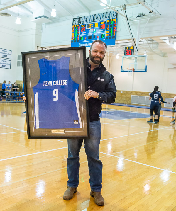 Aubrey Alexander accepts a framed #9 Wildcat jersey, representing his Penn College graduation year.