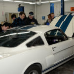A 1966 GT350 owned by club member Robert "Fritz" Christ (right) draws a crowd in the college's transmission lab ...