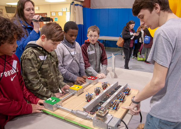 Jon R. German, an electrical technology student from West Grove, engages students in a race – which uses a time delay – to see who can hit their button the quickest, on cue, to light green, yellow or red light on a traffic signal.