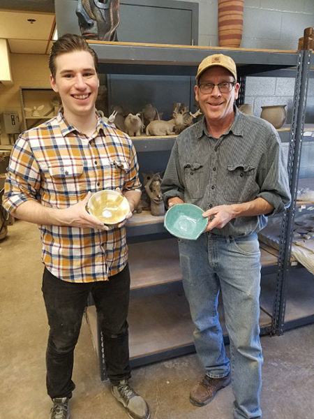 Instructor David A. Stabley (right) and Luke A. Bierly, a graphic design major in his ceramics class this semester, display donations to the Soup and a Bowl fundraiser. (Photo provided)