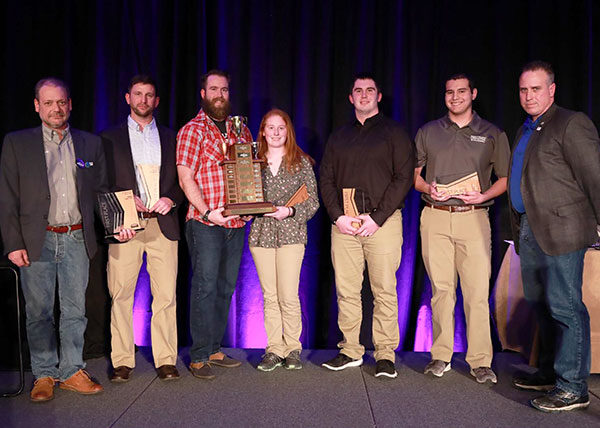 The two-year Penn College team displays its championship trophy (earned in the National Association of Home Builders’ student competition) at the International Builders’ Show in Las Vegas. From left are instructor Barney A. Kahn IV; students Joe J. Hetrick, of Painted Post, N.Y.; Drew P. Miller, of Williamsport; Hanna M. Gibson, of Allison Park; Nicholas T. Bonsell, of Tyrone; and Nathan I. Tabon, of Allison Park; and instructor Levon A. Whitmyer.