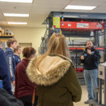 Jose M. Perez, instructor of plastics technology, talks with visitors about the thermoforming lab and the hands-on learning that students do there.