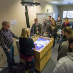 Lyon (left foreground) and Anita R. Wood, an associate professor of computer information technology who helped facilitate the sandbox installation, orient students.