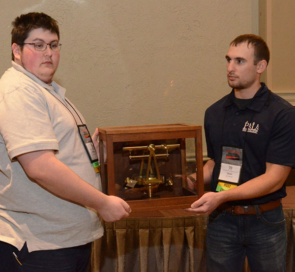 Broadt and a Penn State student host display auction items during a scholarship fundraiser.