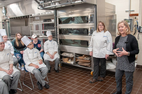 Chefs Suzann Mayer, retired faculty member, and Susan Notter, USA sales professional for Max Felchlin, provide industry insight and advice to baking and pastry arts students before judging a wedding cake competition comprised of final projects by students in Cake Decorating II.