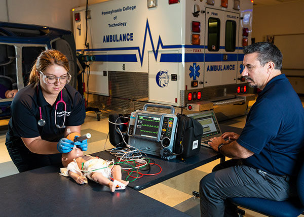 Under the supervision of Brady L. Breon, assistant professor of paramedic, Penn College student Alyssa M. Ogden, of Lawrenceville, performs an endotracheal intubation on a pediatric manikin in the college’s well-equipped paramedic laboratory. The college will host an information session on its emergency medical services programs on April 24.