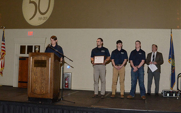 Beneath the PSLS's golden anniversary logo, President Johnson accepts the club's award ...