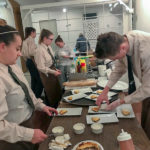 Student managers for the event, Gray and Jordan, plate the dessert: key lime pie with coconut panna cotta.