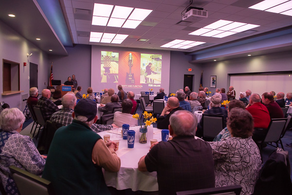 Rebecca A. Davies (at podium) and Anthony F. O’Koren deliver The Dr. Welch Workshop presentation and share various projects and their extreme excitement for the makerspace. On screen is one of Davies’ wall guitar mounts that she created in the workshop. Davies is enrolled in building construction technology: masonry concentration; O’Koren is an electronics and computer engineering technology student. 