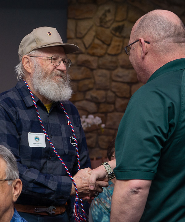 Denice Palmeter, '59, electronics, proudly wears his honor cord while exchanging sincere appreciation with Beaver.