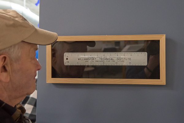A measure of past success in a latter-day haven for tinkerers: Olson views a WTI ruler displayed on a makerspace wall. The ruler originally belonged to the late Joseph B. Gehret, a 1938 graduate, who received it when he was a student. 