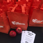 Complimentary tote bags carried apples and other goodies, along with information on helping The Cupboard at the cash register and through direct donations.