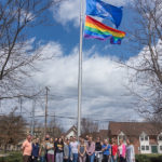 Allies from a physician assistant class surround the flag in the LEC Loop.