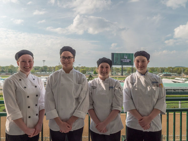 During Derby Week 2018, Pennsylvania College of Technology students, from left, Bridget M. Callahan, of Pottsville; Bailey L. Frey, of Watsontown; Bethany R. Taylor, ’18, of Moosic; and Stephanie C. Myers, ’18, of Catawissa, step away from the kitchens at Churchill Downs in Louisville, Ky., to take in the facility’s world-famous track. Twenty-eight students and 10 alumni will again join the hospitality team for the 2019 Kentucky Derby on May 4.
