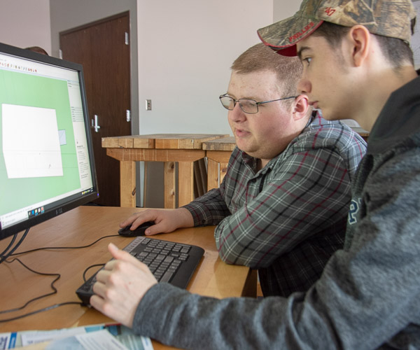 Architectural technology student Donny J. Reisch assists a visitor during a Google SketchUp hands-on session.