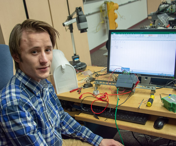 David M. Zlotnicki, an electronics and engineering technology student from Oil City, shows a project that uses a programmable logic control to sense and control temperature using a light bulb.
