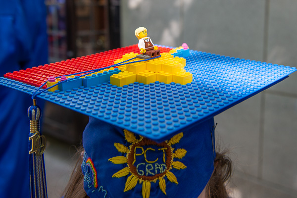 Embroidery and Legos colorfully meet on the regalia of Kimberly P. Masullo, who received an associate degree in building construction technology on Saturday morning.