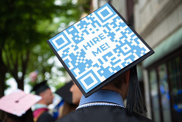 The cap of Tristan D. Scott, a web and interactive media graduate (cum laude) – and recipient of a faculty award in that major – includes a less-than-subtle message (ingeniously surrounded by a QR code that leads to his portfolio).