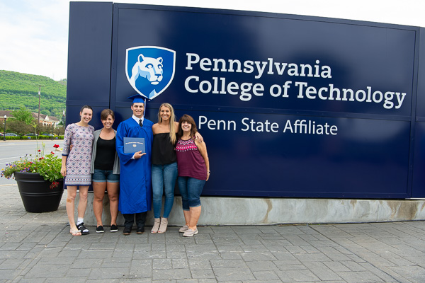 Jacob R. Courtley, a landscape/horticulture technology: landscape emphasis grad, joins his family at the college sign.