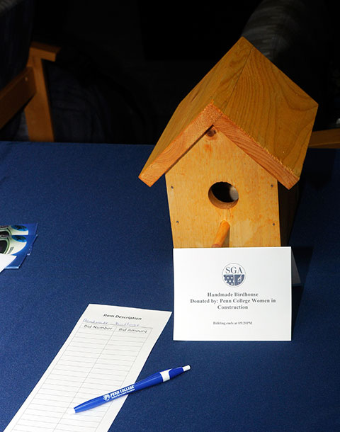 A number of birdhouses, bearing a woodburned college brand on the backside, were handcrafted by Women in Construction.