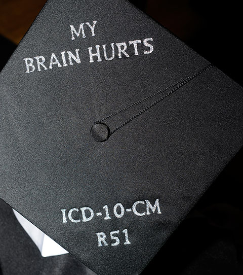 Set to begin a position at Geisinger, Nau's mortarboard includes the diagnostic code for a headache ... relief from which can surely be found in finishing college and finding employment.