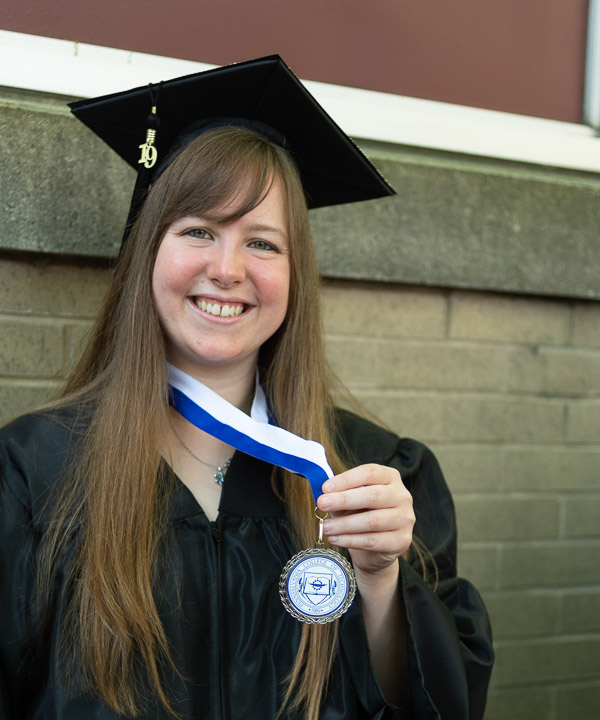 Applied human services graduate Stephanie L. Johnson displays a medal commemorating her service as a resident assistant.