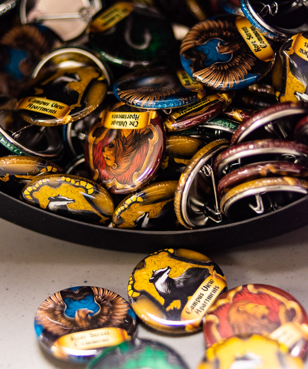 Souvenir buttons are emblazoned with names of on-campus housing complexes.