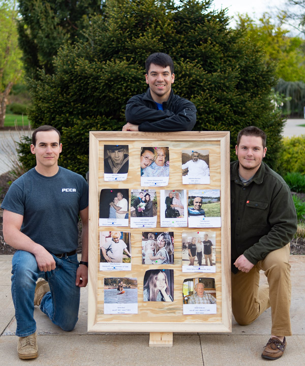 PCCA members (from left) Hayden N. Beiter, of Williamsport; Matthew M. Hober, of Basking Ridge, N.J.; and Michael J. Deragon, of Fort Washington; display a photo board memorializing loved ones who battled cancer. The board was designed and built by classmate Josh E. Rosenberger, of Waynesboro.