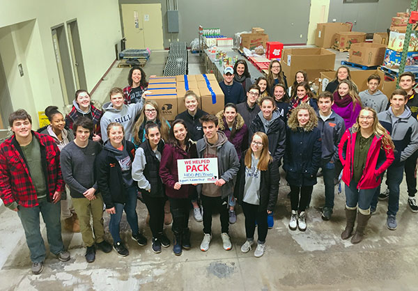 Participants and their advisers celebrate a successful community service project at the Central Pennsylvania Food Bank (which provided the photo).