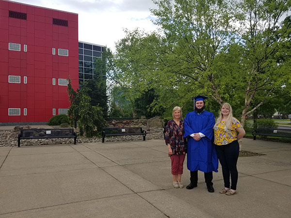 Brian J. Daniels, a mechatronics engineering technology major from Lake City, stands for a Madigan Library photo with his support team before leaving campus for Friday's ceremony.