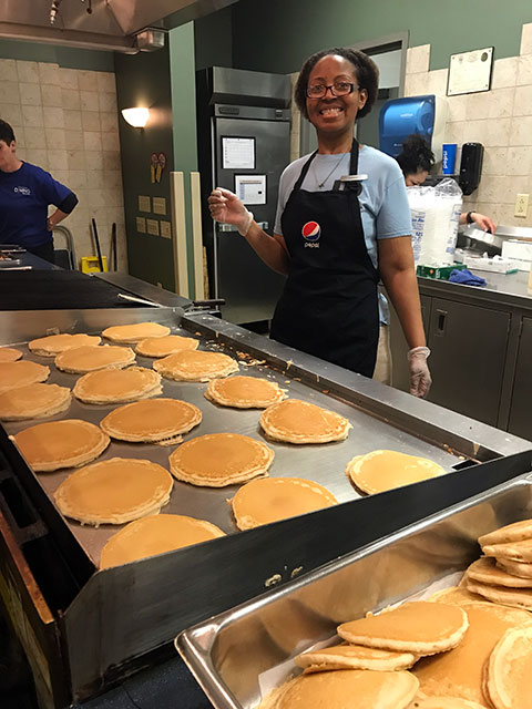 LaToya C. Simmons, assistant cook at Capitol Eatery, puts a customary smiling face on a late-night assignment.